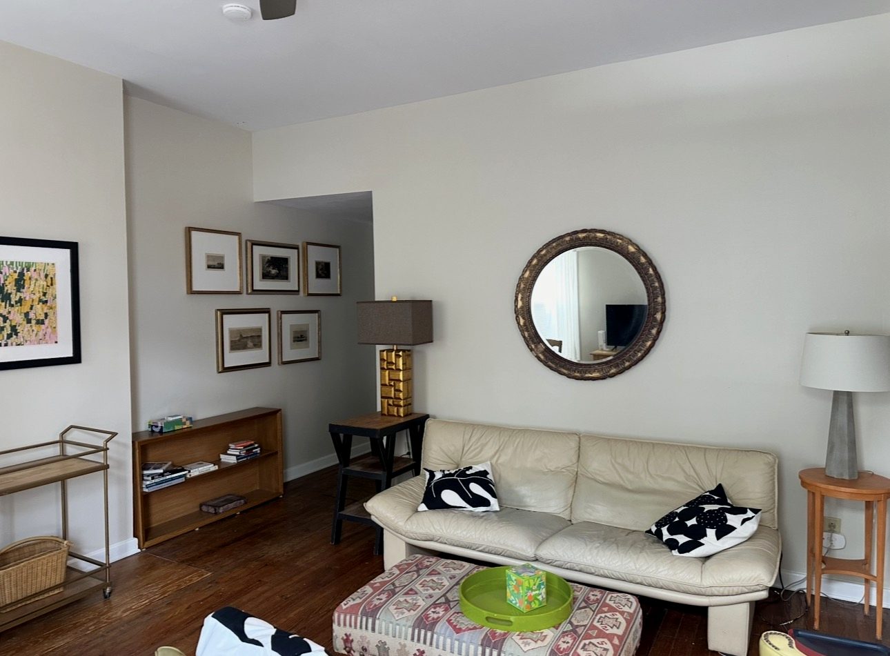Living room of the Italian Village apartment with leather sofa and gallery wall